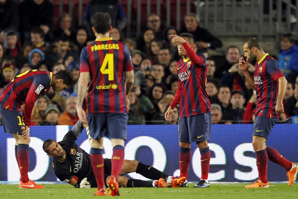 Barca's keeper Victor Valdes (bottom) is surrounded by his teammates as he lies injured. He is leaving the club in June and a ban on transfers will mean Barca cannot replace him until summer 2015. Photo: Reuters
