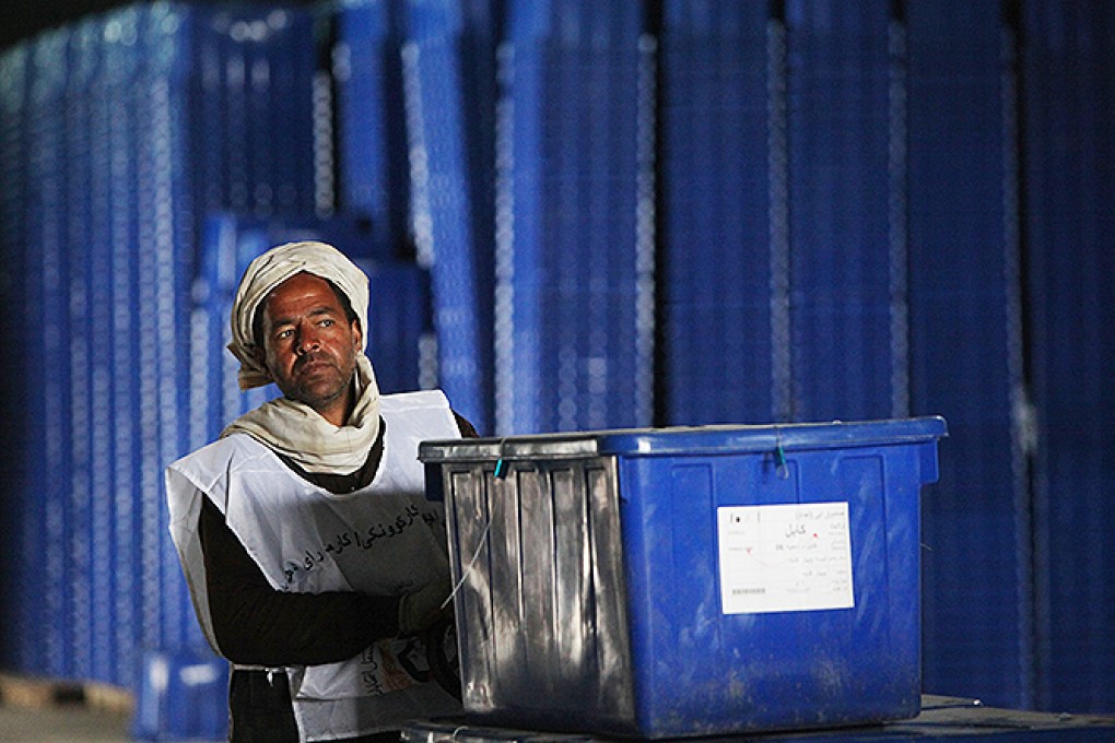 An Afghan election commission worker pushes ballot boxes in IEC warehouse in Kabul. Photo: Xinhua