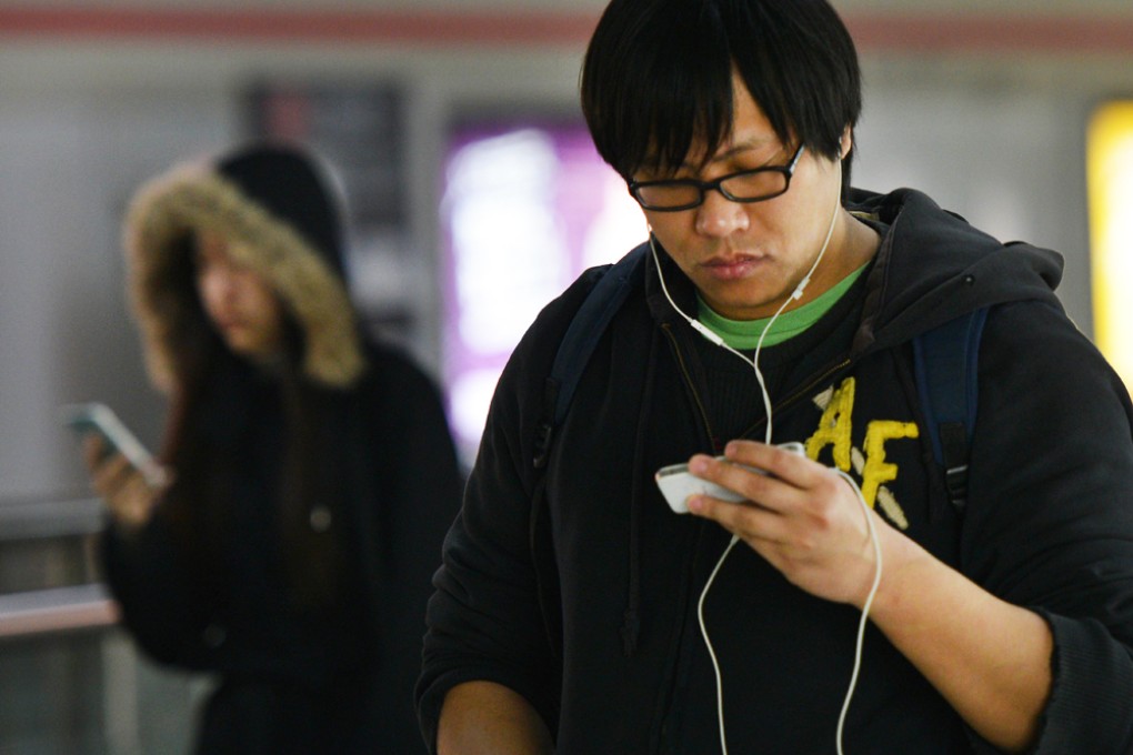 People use their mobile devices in a metro station in Shanghai on March 12, 2014. Photo: AFP