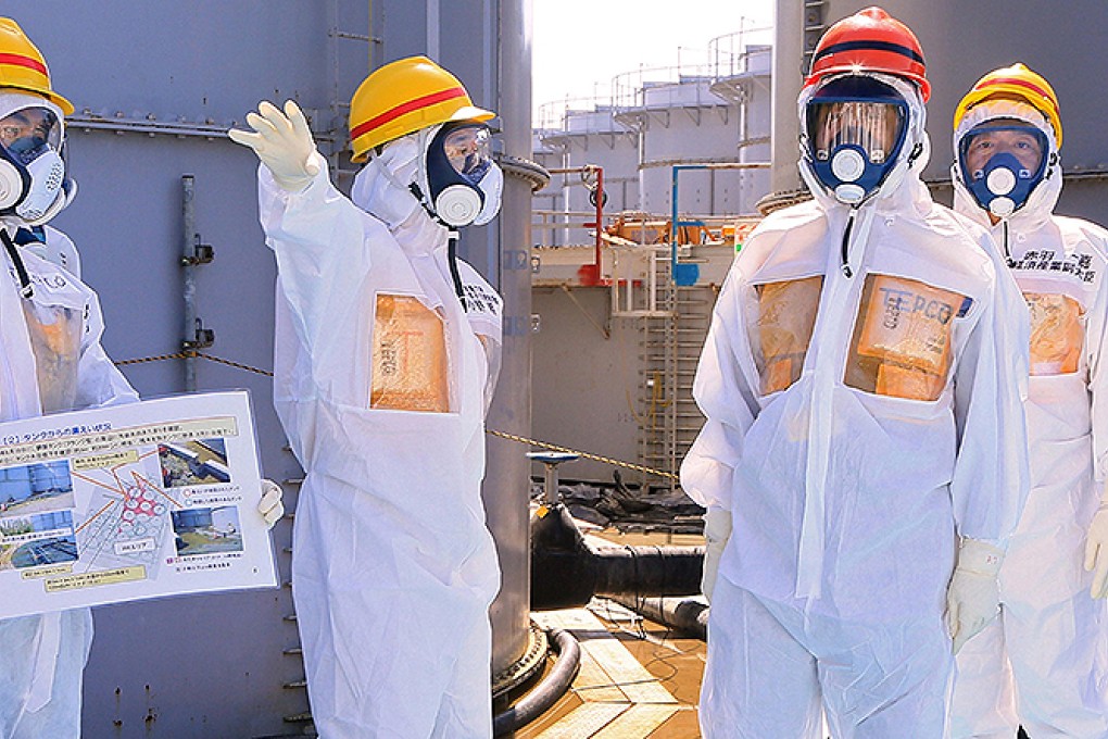 Japan's Prime Minister Shinzo Abe (second right) is briefed about tanks containing radioactive water by Fukushima nuclear power plant chief Akira Ono. Photo: Reuters