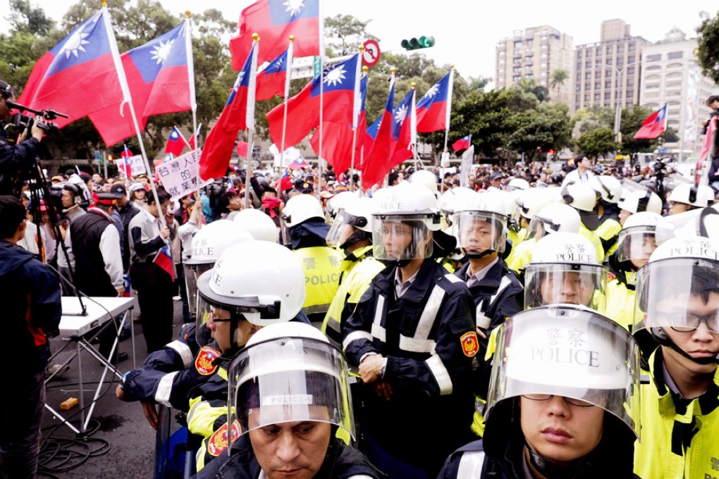 Riot police separate pro-China activists holding Taiwan's nationals flags from students occupying the parliament in Taipei, Taiwan. Photo: EPA