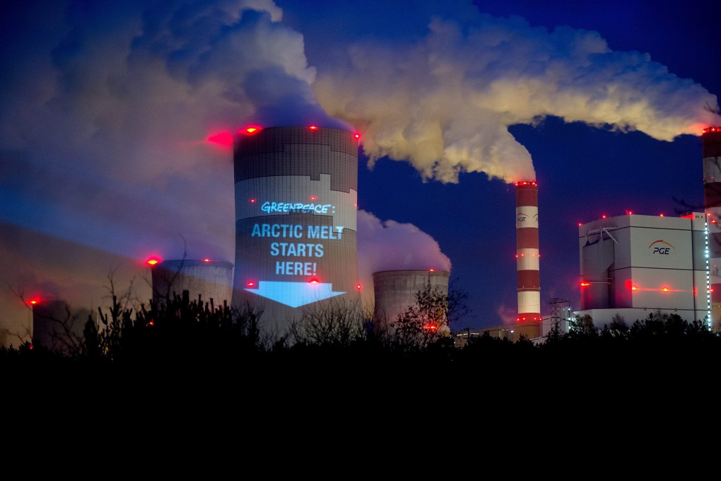 Greenpeace activists project a slogan onto the cooling tower of the brown coal fired Belchatow power plant, in Belchatow, Poland. Photo: EPA