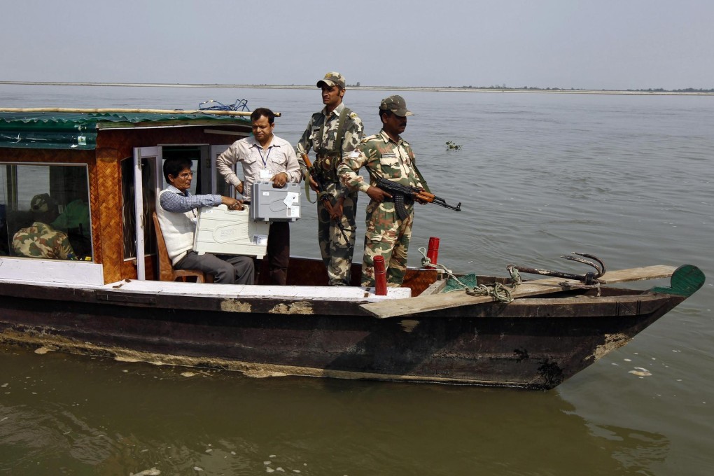 Polling officers and armed guards transport electronic voting machines along a river in the northeastern state of Assam. Photo: Reuters