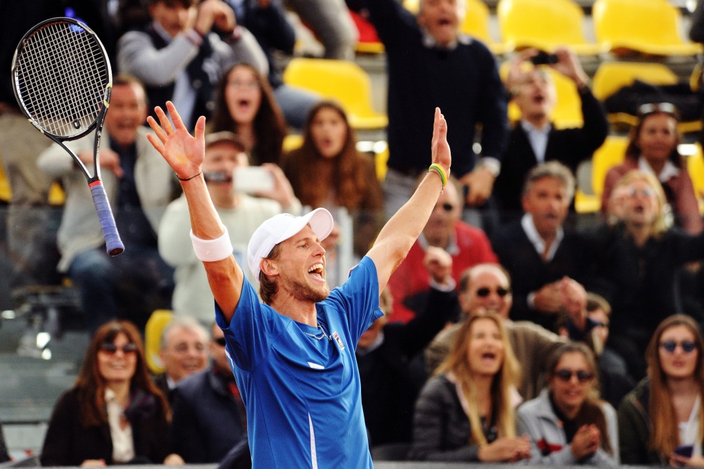Italy's Andreas Seppi throws his racket in the air as he celebrates beating Britain's James Ward in Naples, Italy. Seppi won 6-4, 6-3, 6-4 in the decisive match. Photo: AP