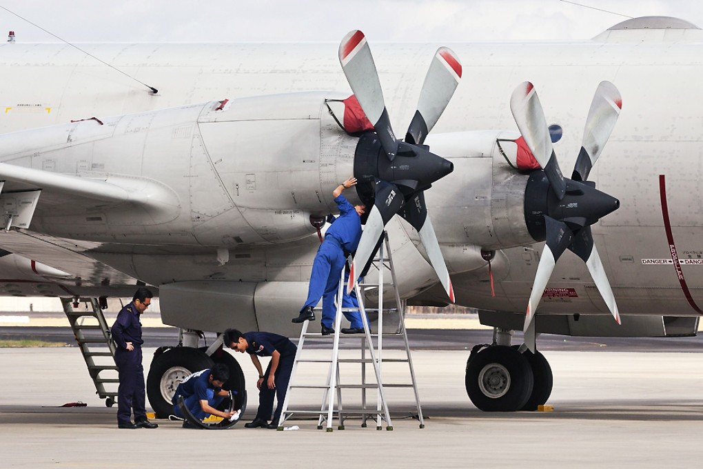 Japanese ground crew prepare a Japanese Air Force Orion plane for takes off from Pearce Airbase near Perth to join the hunt for the missing MH370 plane in the Indian Ocean on April 6, 2014. Photo: AFP