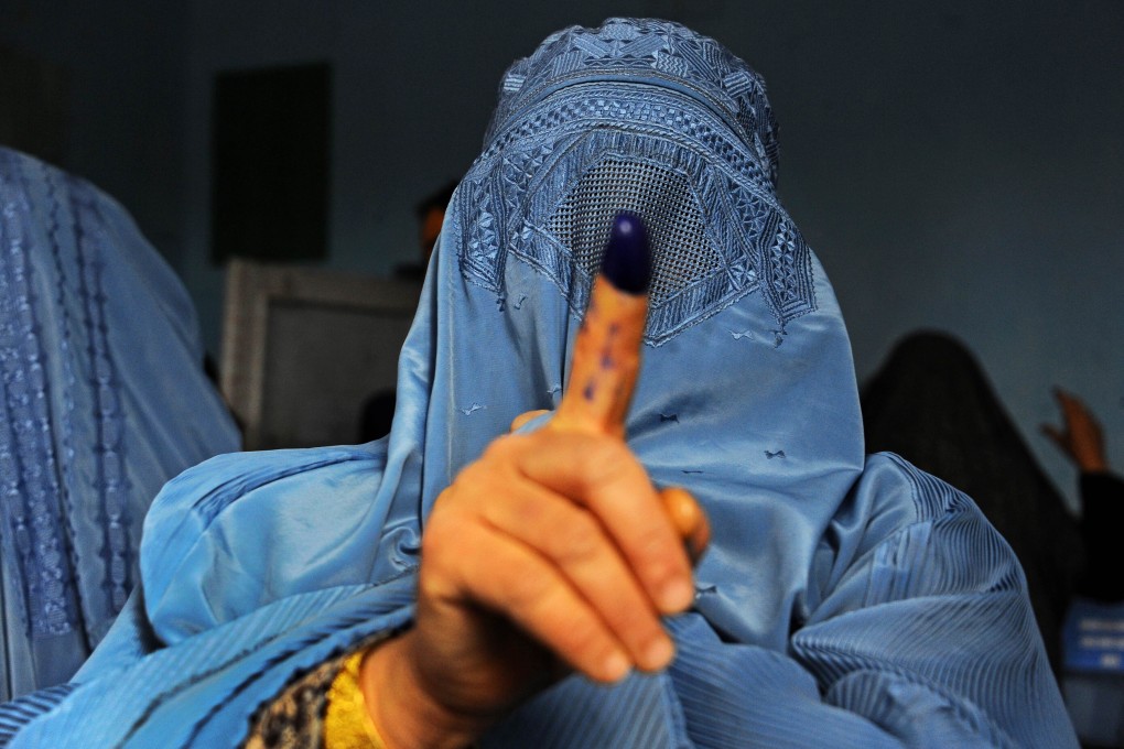 An Afghan woman shows her inked finger after voting at a polling station in the northwestern city of Herat on Saturday. Photo: EPA