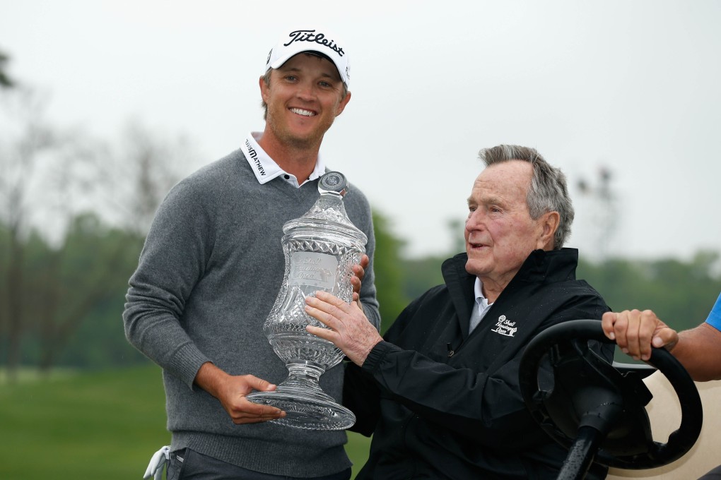 Matt Jones is given his trophy by former US president George HW Bush. Photo: AFP