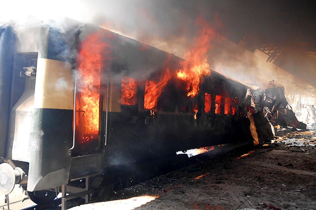 Fire rages from a compartment of a passenger train after a bomb blast at a railway station in Sibi, southwest Pakistan. Photo: Xinhua