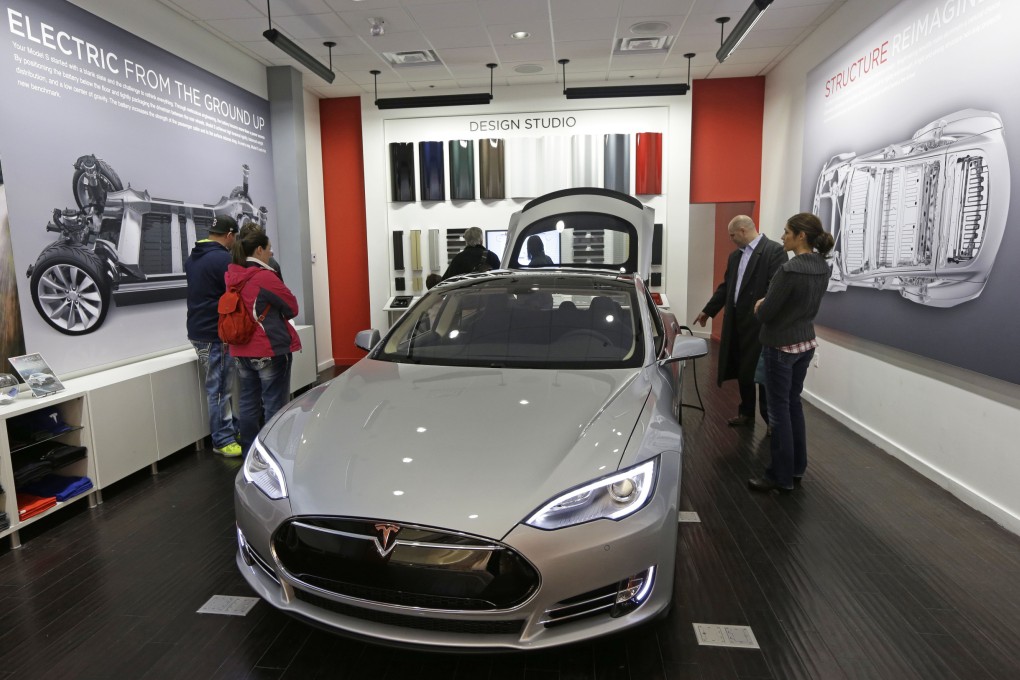 Customers check out a new Tesla electric car at a showroom in Kenwood Towne Centre, Cincinnati. Photo: AP