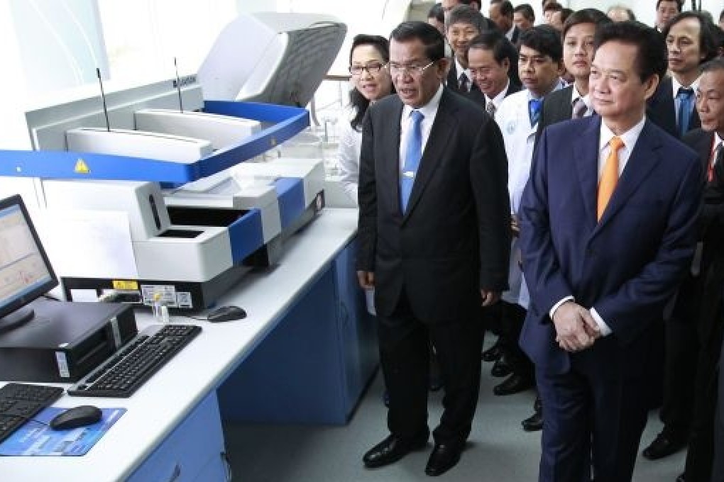 Vietnamese Prime Minister Nguyen Tan Dung (2-R, first row), and his Cambodian counterpart Hun Sen (2-L), visit a lab at Cho Ray hospital in January 2014.