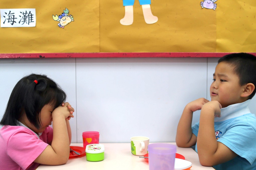 Children pray before getting a snack at a kindergarten in China. Education authorities have stepped up inspections on nursery schools after a string of safety scandals. Photo: The Beijing News