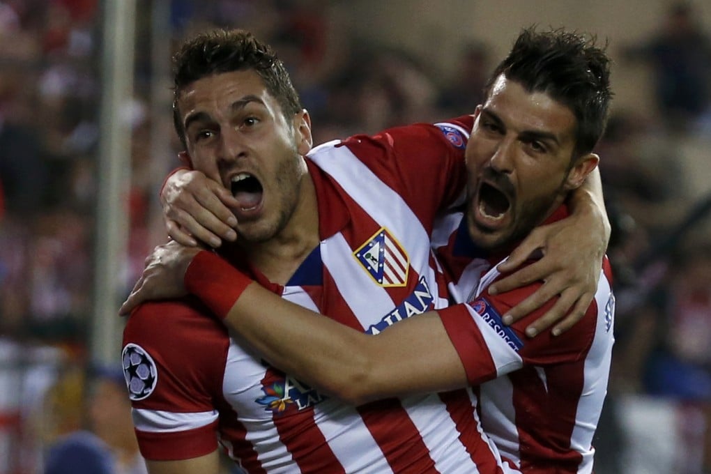 Koke celebrates his goal with David Villa. Photo: Reuters
