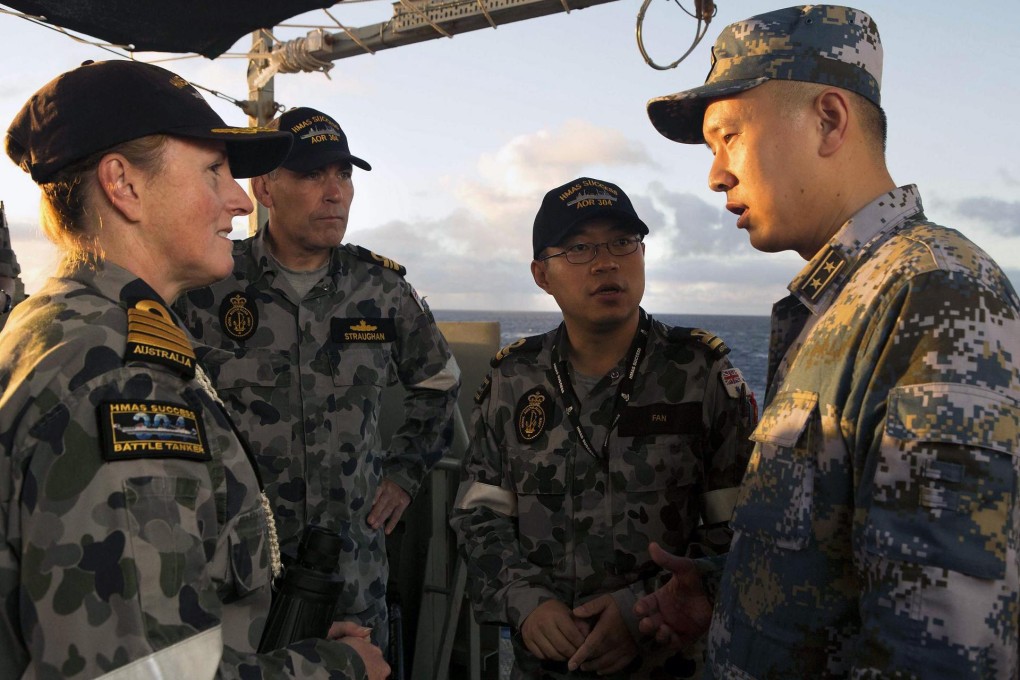 PLA Navy liaison office commander Lin Wan talks to Captain Allison Norris, commander of Australia's HMAS Success, during the hunt for MH370 yesterday. Photo: Reuters