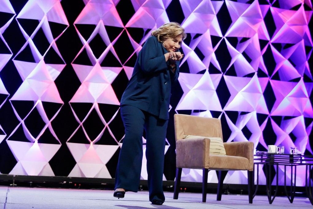 Clinton ducks as a woman throws a shoe. Photo: AFP