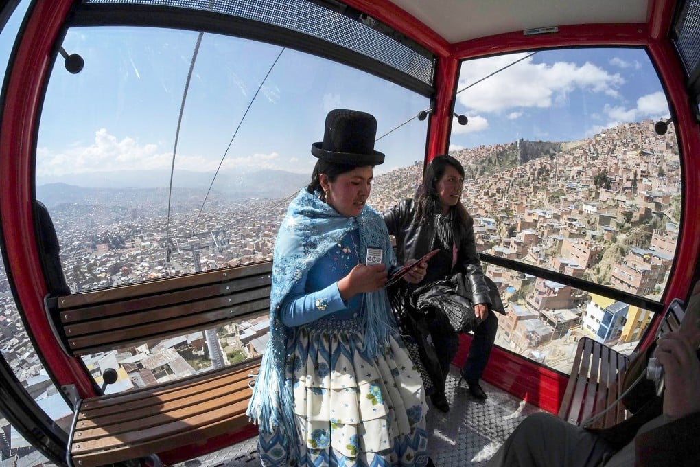Two women take the cable car from El Alto to La Paz during a trial run for one of three urban services. Photo: Reuters