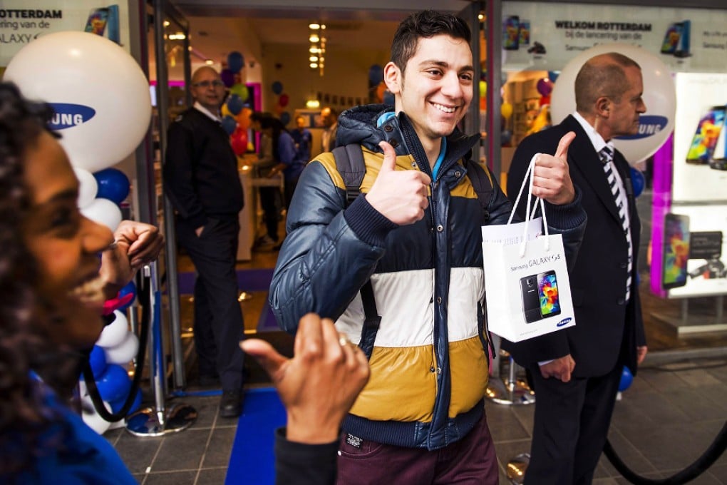 A customer gives a double thumbs up after he bought a new Samsung Galaxy S5 in Rotterdam, The Netherlands. Photo: EPA