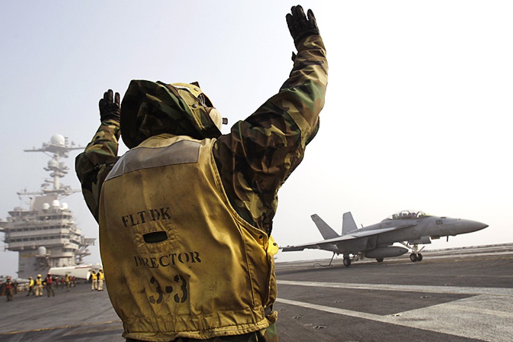 Flight deck crew signal a US Navy F-18 jet fighter on the deck of the USS George Washington aircraft carrier during a joint military exercise with South Korea. Photo: AP