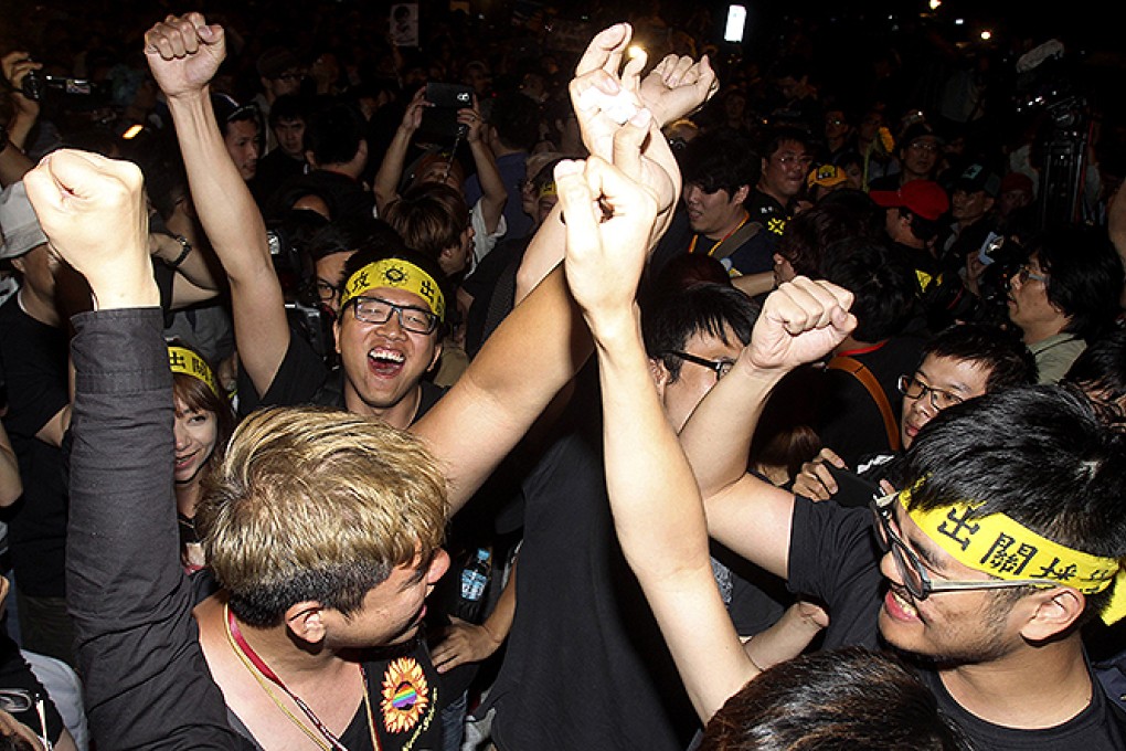 Student protesters against a trade pact with China cheer after leaving the legislative in Taipei. Photo: AP