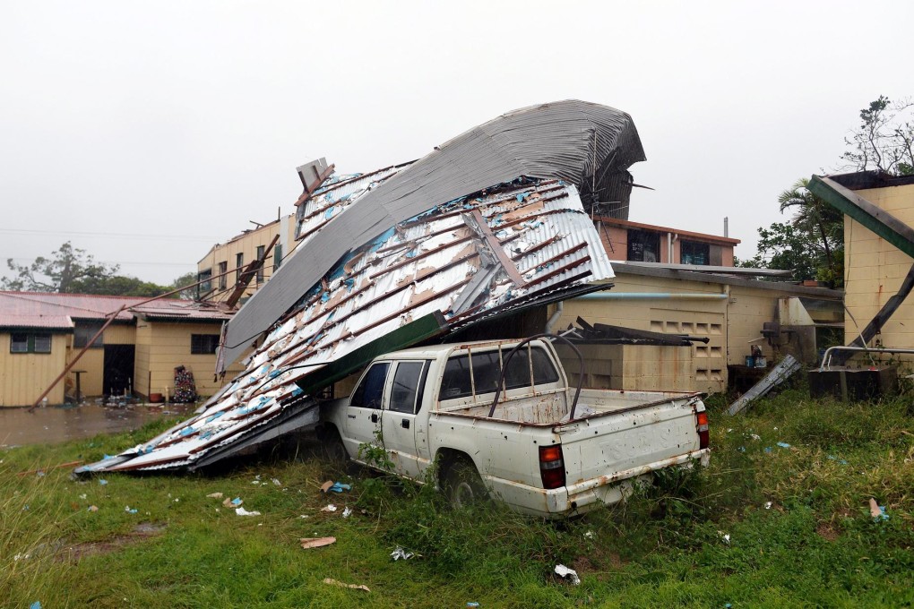 A fallen roof lies on a vehicle in Cooktown, Queensland, yesterday after Cyclone Ita hit the town. Crops were also damaged. Photo: EPA