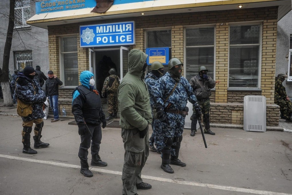 Armed men guard the seized police headquarters in Slavlansk. Pro-Russia protests in restive eastern Ukraine are intensifying. Photo: EPA