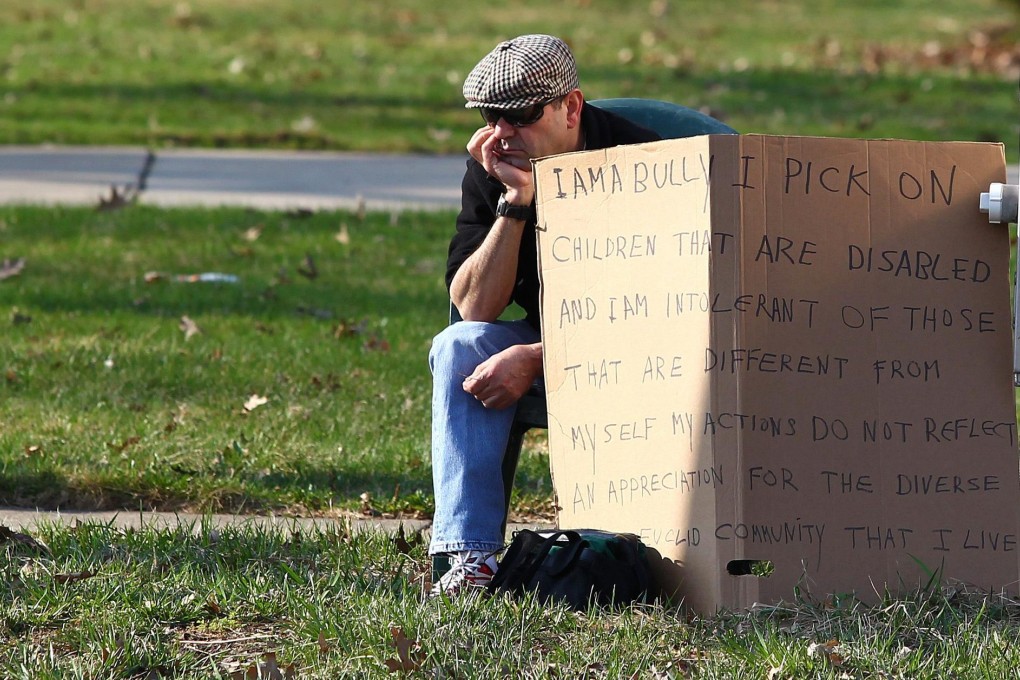 Edmond Aviv sits with his sign on a street corner. Photo: Reuters