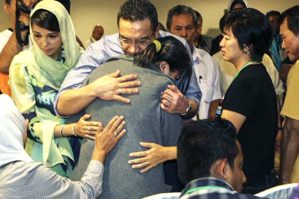 Malaysian Defence Minister and acting Transport Minister Hishamuddin Hussin hugs a family member of a missing Malaysian Airlines flight MH370 during his visit in Putrajaya on March 29, 2014. Photo: EPA