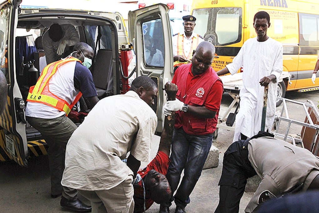 A Red Cross worker and other volunteers help move a body into a mortuary. Photo: Reuters