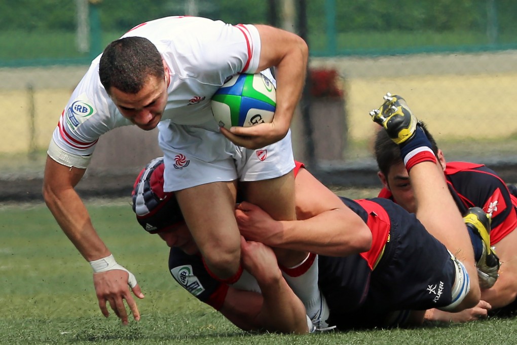 Georgia's Revaz Brodzeli tries to break away from the Hong Kong defence in their match at Hong Kong Football Club. Photos: KY Cheng