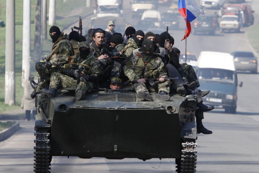 Men wearing military fatigues ride on an armoured personnel carrier in the eastern Ukrainian city of Kramatorsk yesterday.Photo: AFP