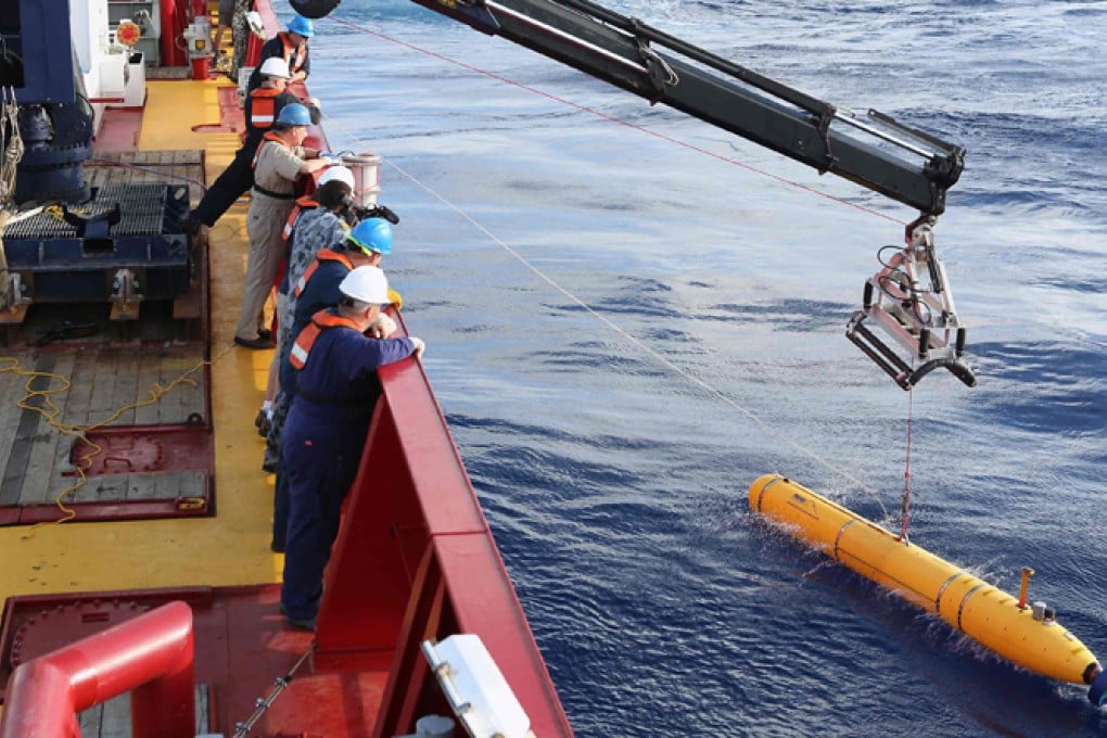 Crew aboard the Australian Defence Vessel Ocean Shield watch as the US Navy’s unmanned submarine is deployed. Photo: Reuters