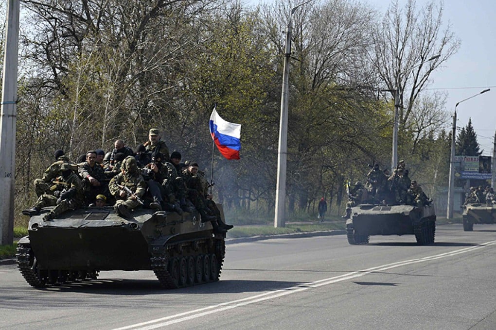 Armed men drive an airborne combat vehicle flying the Russian flag, outside Kramatorsk. Photo: Reuters