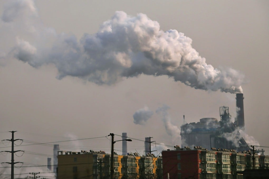 Smoke rises from a chimney of a steel plant next to residential buildings on a hazy day in Hebei, some 140 km south of Beijing. Photo: Reuters