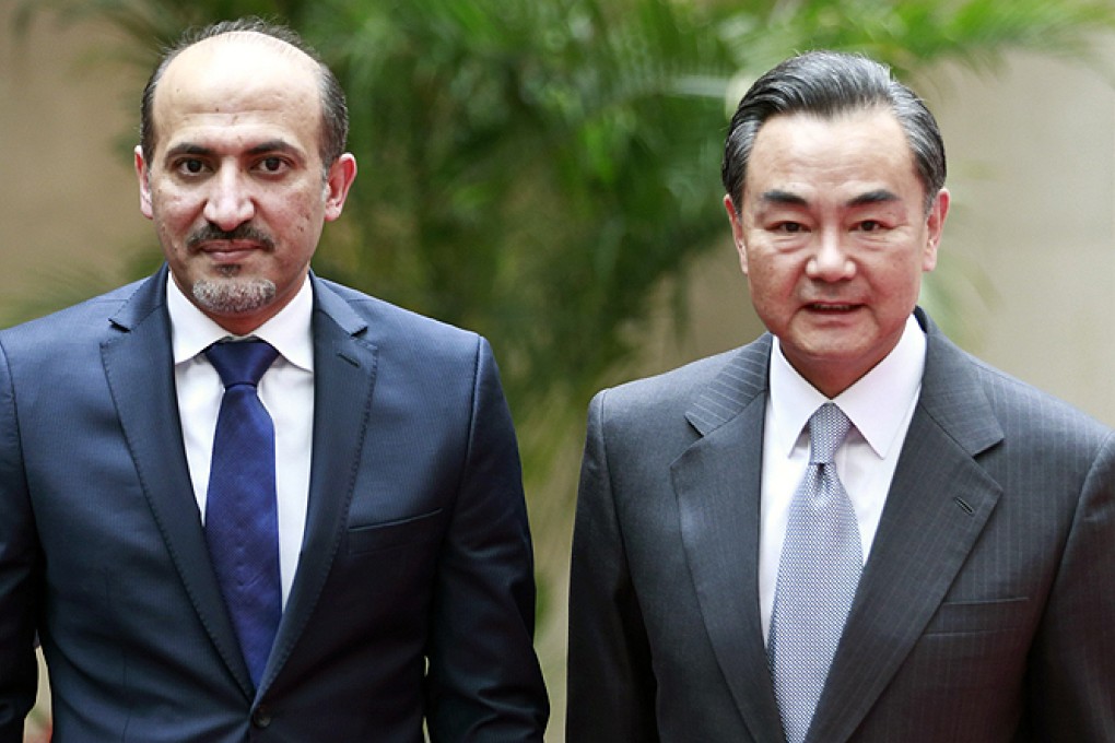 China's Foreign Minister Wang Yi with the head of the Syrian National Coalition Ahmad Jarba