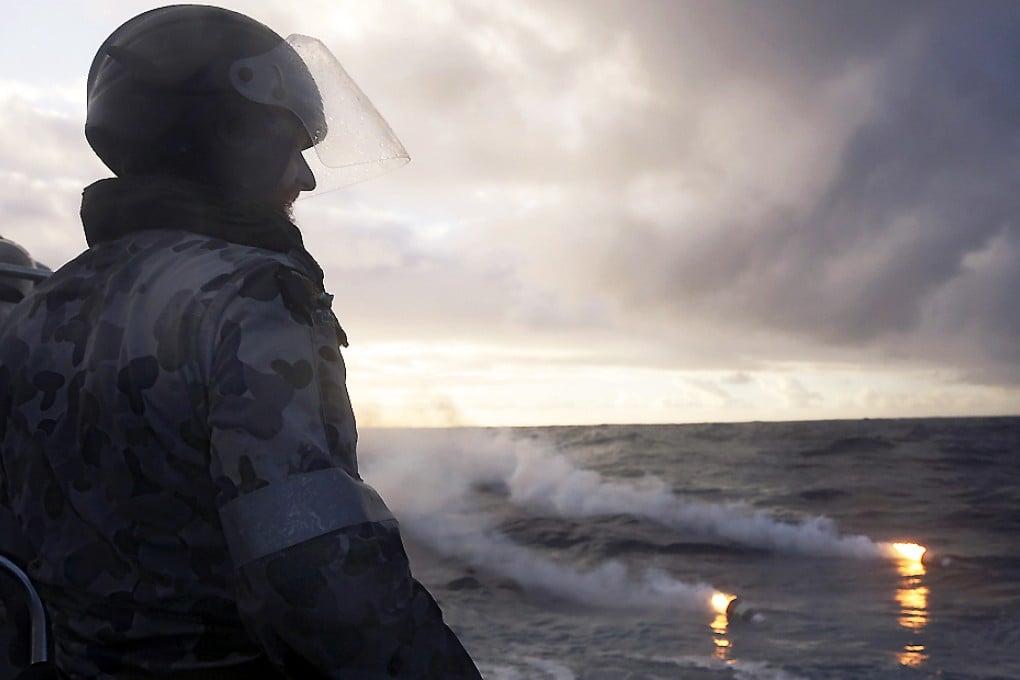 Seaman Morgan Macdonald observes markers dropped from a Royal New Zealand Air Force (RNZAF) P3K Orion after an object was sighted in the southern Indian Ocean during the continuing search for the missing flight. Photo: Reuters