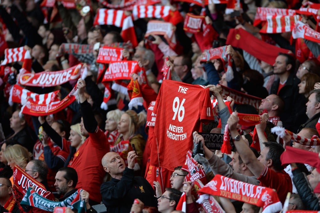 Members of the crowd raise scarfs and team shirts in the air during the  memorial service at Anfield to mark the 25th anniversary of the Hillsborough disaster. Photo: EPA