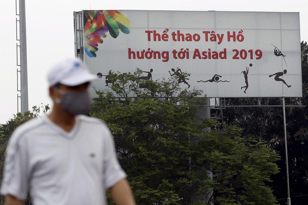 A man walks past a board in Hanoi proclaiming the 2019 Asian Games - but the event will be hosted elsewhere. Photo: EPA