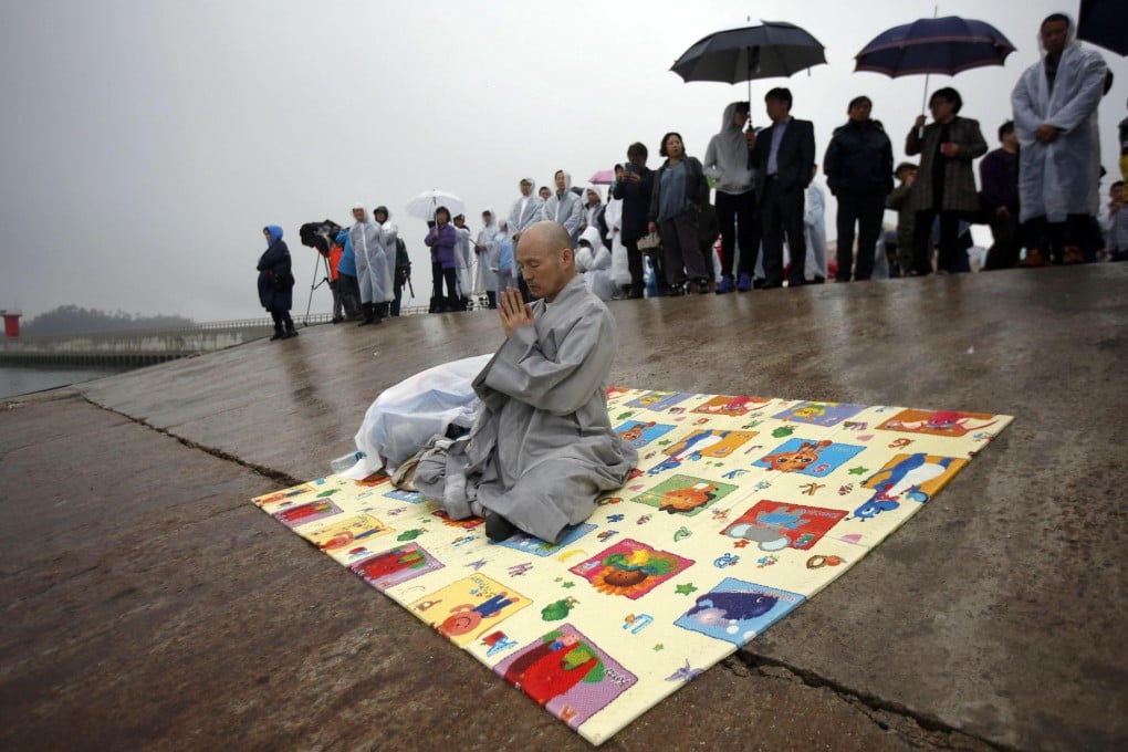 A Buddhist monk prays for missing passengers, mostly students, who were on the ferry when it sank off Jindo. Photo: Reuters