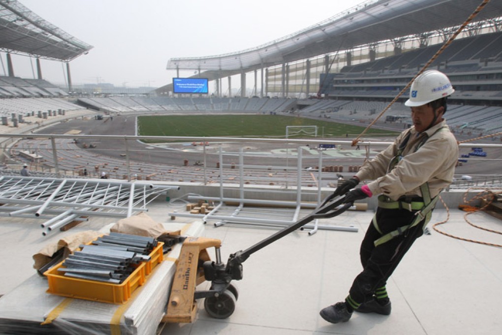 A labourer works at the main stadium for the 2014 Asian Games in South Korea. Vietnam says high costs are one reason it has withdrawn as host for the 2019 Games. Photo: AP