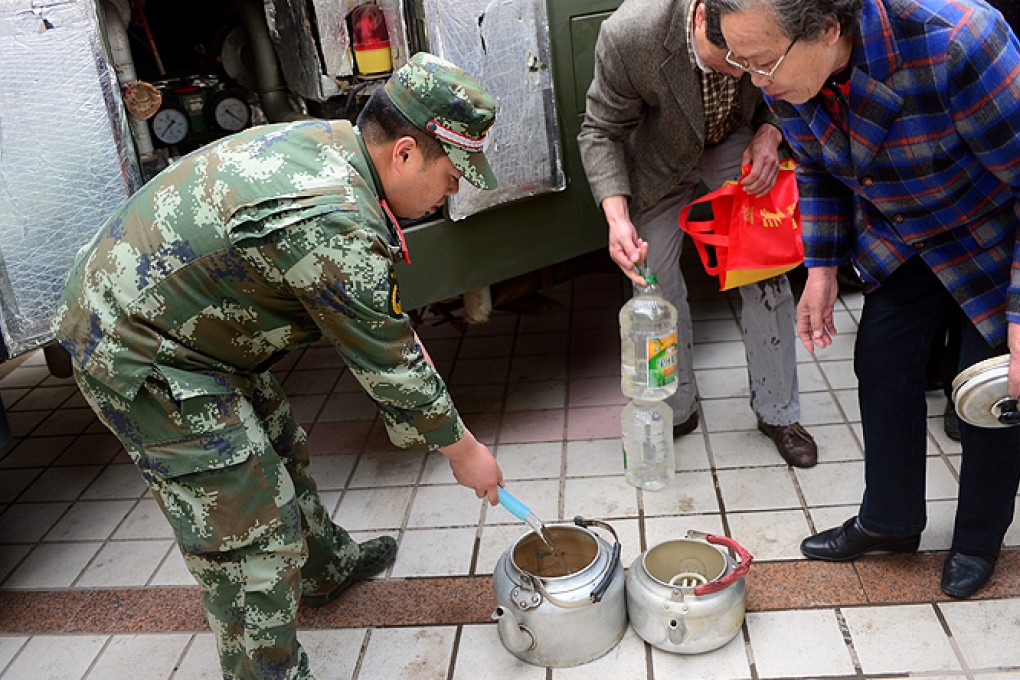 Lanzhou residents get clean water at a community centre after tap water supplies wer deemed unsafe last week. Photo: Xinhua