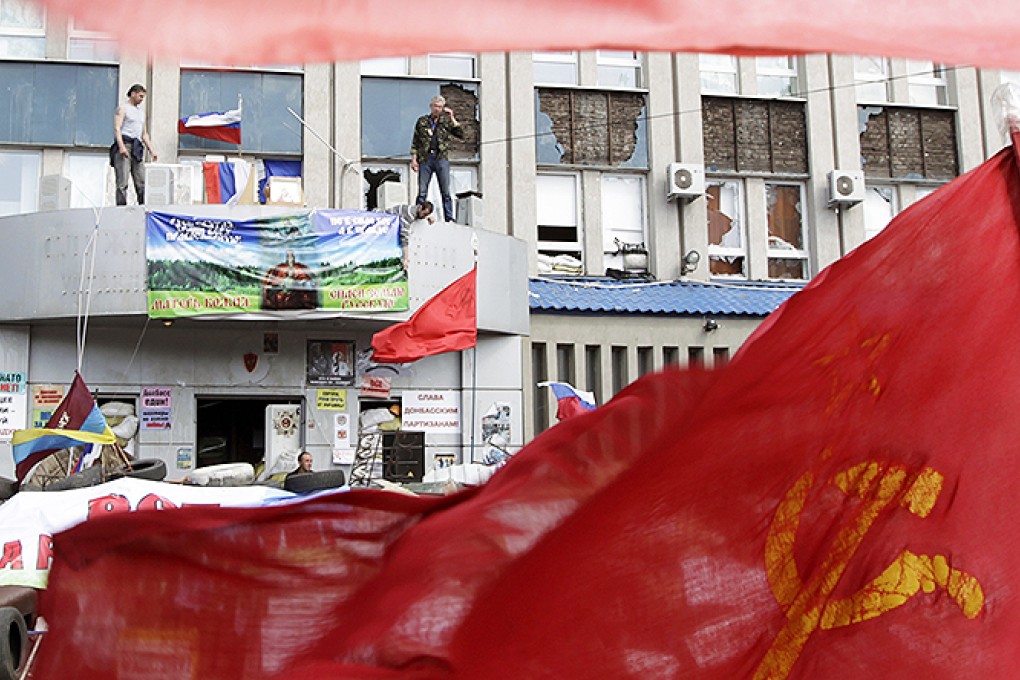 Pro-Russian protesters stand at the seized office of the SBU state security service in Luhansk, eastern Ukraine. Photo: Reuters