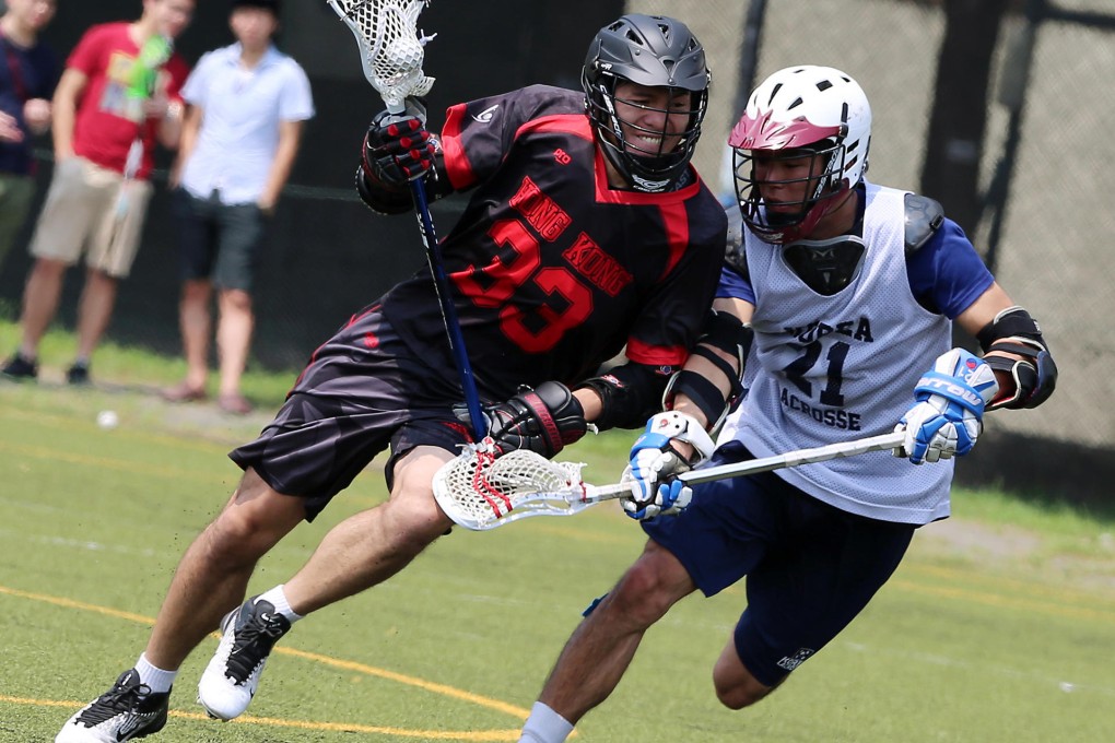 Hong Kong's Kelvin Mak does battle with South Korea's Ryoo Eun-gyoo on their way to a 16-15 win for the hosts in the Hong Kong Lacrosse Open on Friday at the Stanley Ho Sports Centre. Photo: K.Y. Cheng
