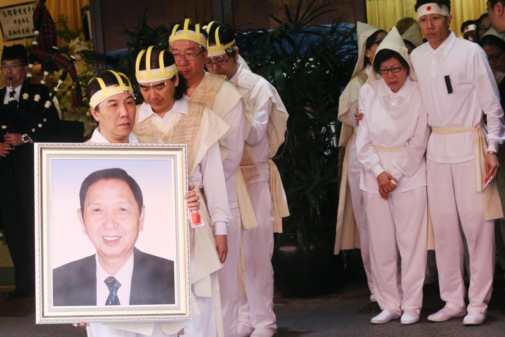 Cheung Wing-hong, the eldest son of Cheung Yiu-wing, holds his father's portrait as relatives and friends mourn during yesterday's funeral in Hung Hom. Photo: David Wong