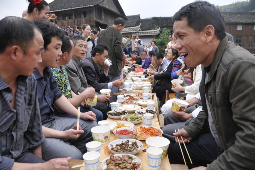 Tourists, officials and residents sit down for a traditional banquet in a southern county. A judge says fostering an 'atmosphere of eating' in court would prevent judges from being wined and dined. Photo: Xinhua