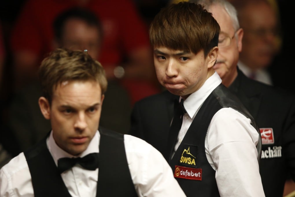 China's Xiao Guodong looks on as Ali Carter of England lines up a shot during their first-round match at the Crucible. Photo: Xinhua