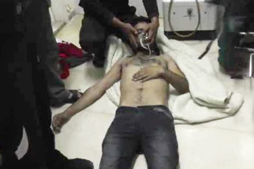 A man lies on the floor with an oxygen mask at a hospital room in Kfar Zeita, Syria on April 12. Photo: AP