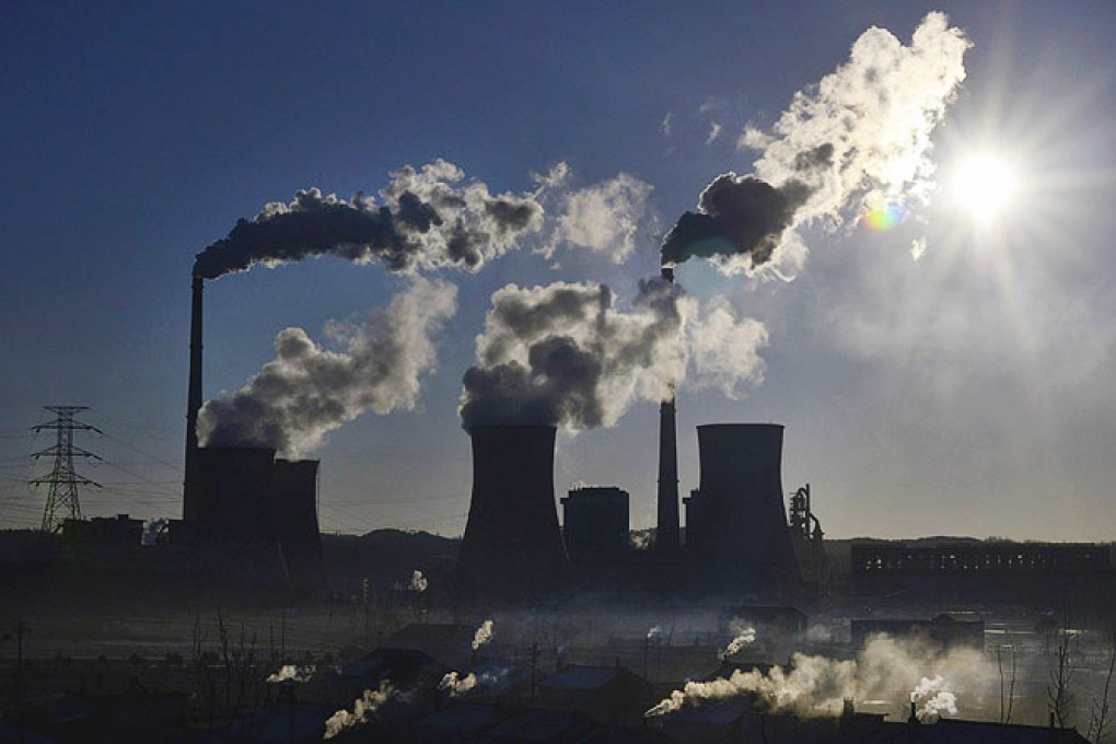 Smoke rises from chimneys at a power plant during sunrise in Fushun, Liaoning province, during sunrise. Photo: Reuters