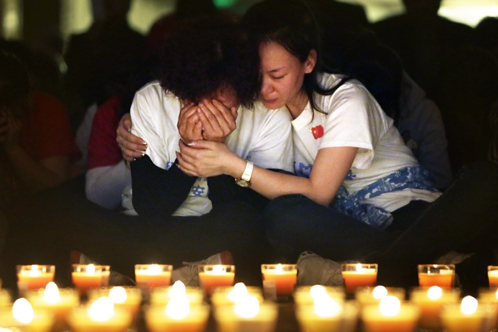 A family member cries as she and other relatives pray during a candlelight vigil for passengers on the missing plane. Photo: Reuters