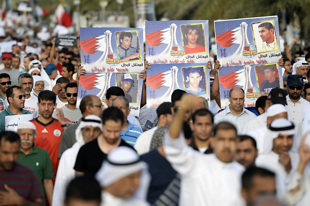 Protesters hold banners as they shout anti-government slogans and ask for releases of political prisoners during a protest in Budaiya west of Manama on April 4, 2014. Photo: Reuters