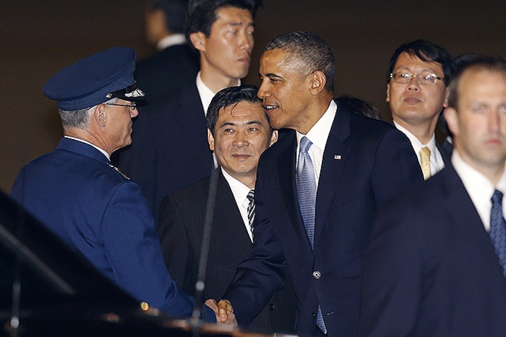 Obama is greeted by an unidentified official at Haneda International Airport in Tokyo. Photo: AP