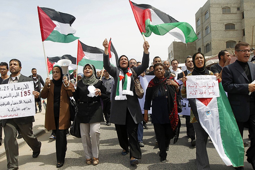 Palestinian demonstrate in support of a new attempt to reconcile the militant Islamist movement Hamas and its PLO rivals in Gaza City on Wednesday. Photo: AFP